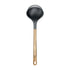 Black ladle with wooden handle on a white background