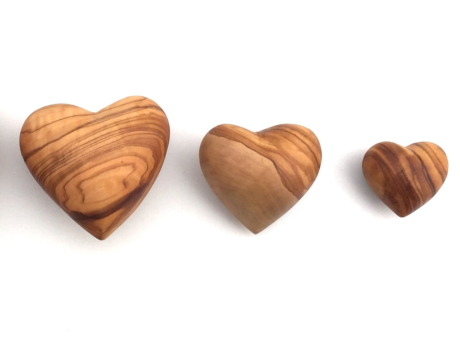 Three wooden hearts of varying sizes on a white background